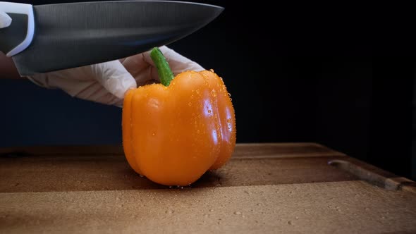 Skilled Cook in White Gloves Cuts Wet Pepper with Knife alt