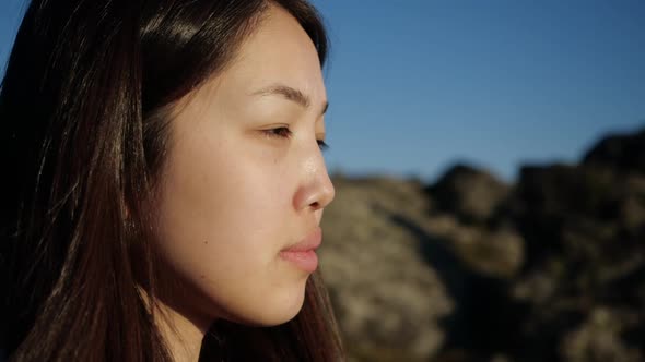 Shooting Close-up of a Girl with Asian Facial Features, Rocks on the Background