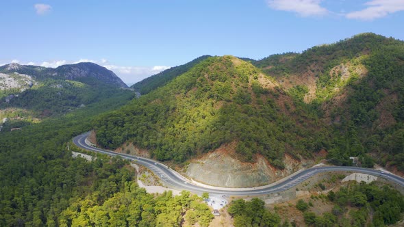 Cars Drive Along a Scenic Highway in a Mountainous Area alt