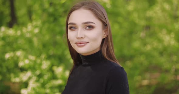 Portrait of Young Female in Black Shirt and with Long Hair Looking at Camera alt