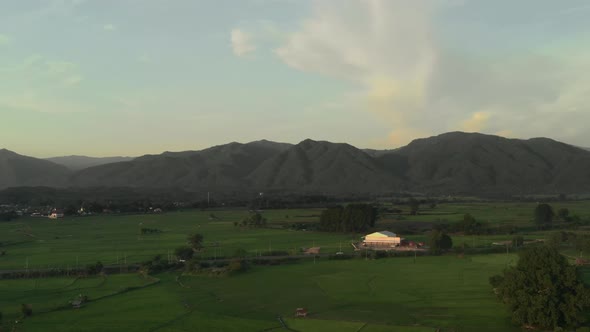 Sunset landscape view countryside farming rice fields and mountains and sun goes down behind mountai alt