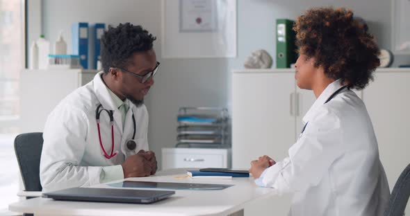 Afroamerican Doctors Having Discussion in Clinic Office alt