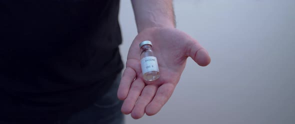 Hand closes the covid 19 vaccine bottle in
