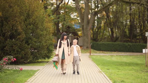 Mom and Son are Walking in the Park in Autumn