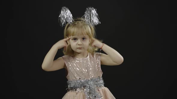 Happy Beautiful Little Baby Girl in Glossy Dress. Christmas. Make Faces alt