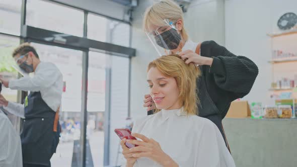 Asian female hairstylist giving an advise for hairdo, haircut and color for caucasian woman's hair. alt