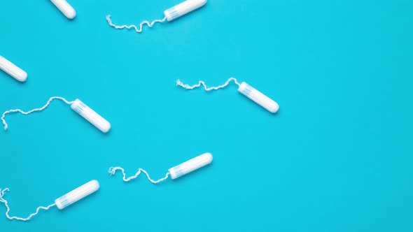 Menstrual tampons move on a blue background. Cotton tampon for women. alt