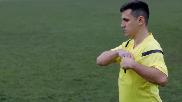 Football Soccer referee whistles and shows penalty and yellow, red card. alt