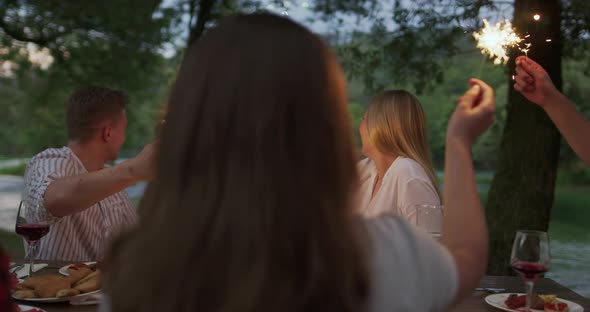 Youth Friendship Concept  Hands Toasting Red Wine Glass Beside River at Nightime alt