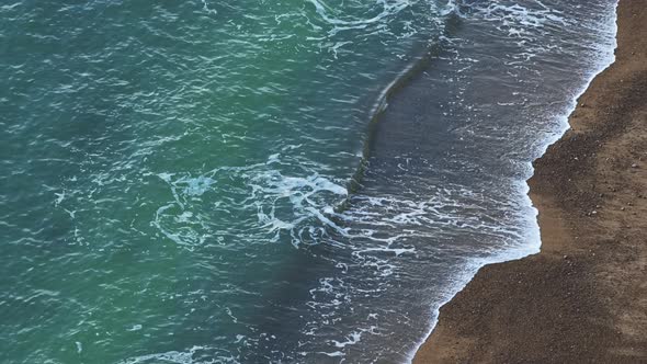Aerial Drone of Sustainable Renewable Hydro Power Energy with Ocean Waves Breaking on Sandy Beach on alt