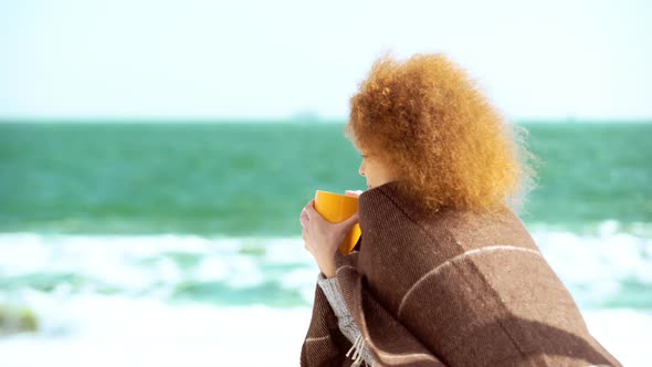 Beautiful Pensive Redhead Woman at the Beach Watching the Sea