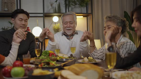 Asian family having dinner at dining table at home alt