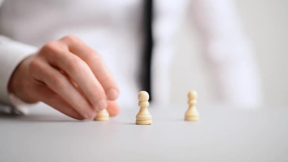Hand Of A Businessman Positioning Chess Pawn Pieces In To A Pyramid Structure