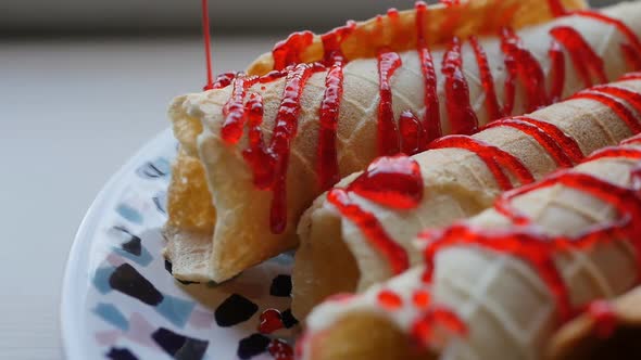 Dolly Shot of Crispy Waffle Rolls Pour a Stream of Red Strawberry or Raspberry Syrup Into a Flat