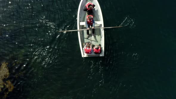 Wooden Boat With People Rowing On Turquoise Water Near Flatey Island, Breidafjordur Bay, Iceland. alt