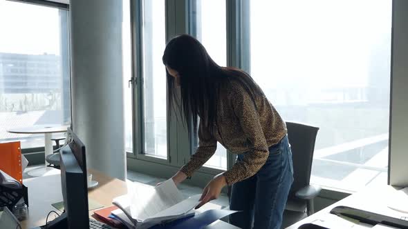 A Young Woman Sneaks Into the Office and Searches Documents alt