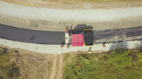 Aerial View of New Road Construction with Workers and Asphalt Laying Machinery at Work alt