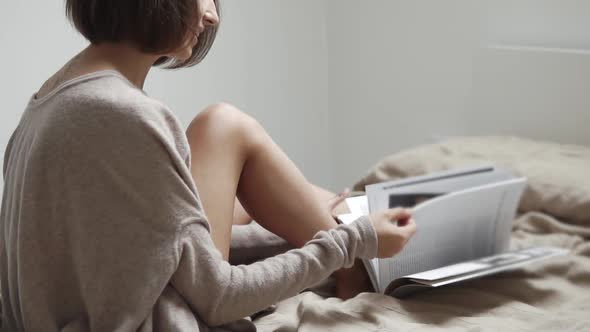 Young Female Student Browses the Magazine for Training at the University alt