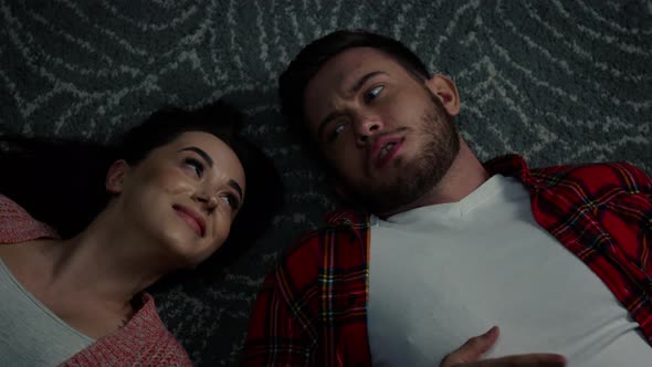 Man and Woman Are Lying On Floor and Talking alt