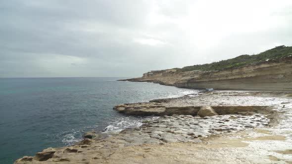 Shallow Water Washes the Shore of Stone Beach Il-Kalanka in Malta