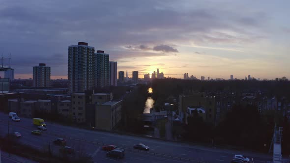 Establishing Aerial drone dolly forward shot of London Canal towards city skyscrapers at sunset alt