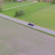 Aerial Video Following A Black Ford Mondeo Stationcar Driving In Green And Yellow Fields - VideoHive Item for Sale