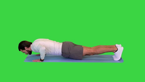Young Caucasian Male in Sportswear Doing Push Ups on a Green Screen Chroma Key