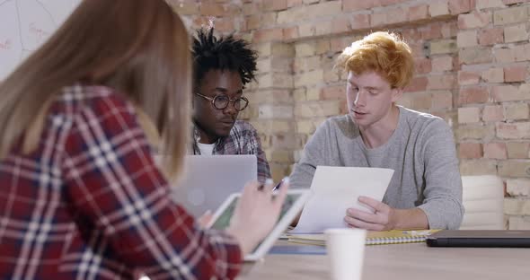 Group of Young Multiethnic Colleagues Sitting in Office and Discussing Project. Portrait of alt