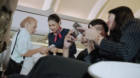 Flight attendant welcomes passengers on a passenger plane while passengers