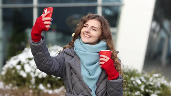 Portrait of Happy Girl Taking Selfie Holding Camera at City Street