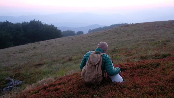 Alone Tourist Sitting in the Mountains Valley