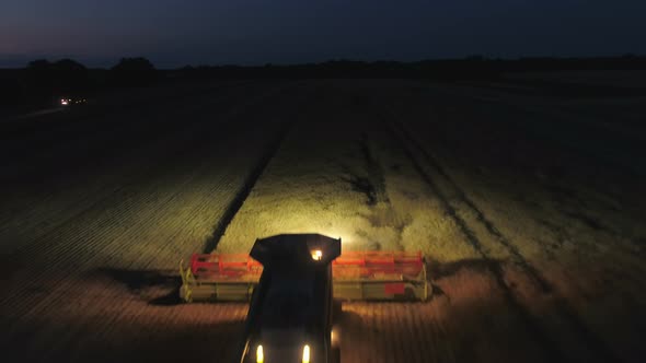 Night Time Harvest Using a Large Combine Harvester in a Field alt