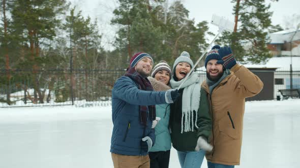 Joyful Friends Taking Selfie in Skating Rink Using Smartphone Camera Posing Having Fun alt