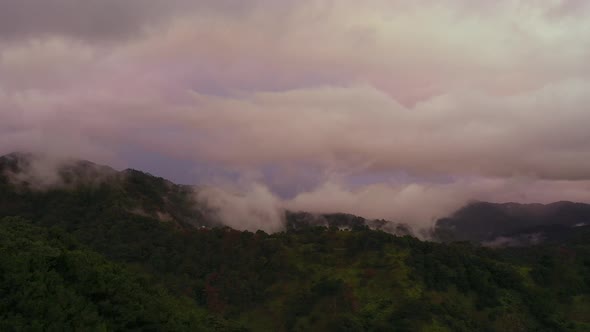Mountain Peaks Covered with Fluffy Clouds During Sunset alt