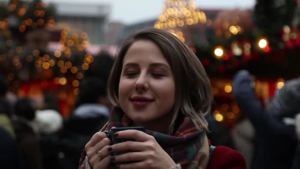 Happy girl with cup in Christmas market