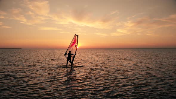 Silhouette of Woman Sailing Windsurf Board Training on Ocean
