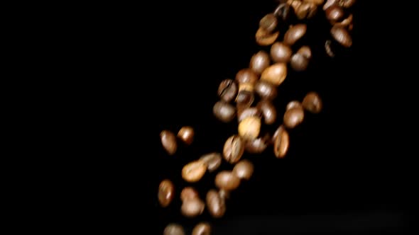 Coffee Beans Pours Down in Slow Motion on Isolated Black Background, Copy Space