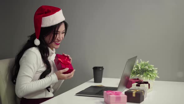 happy woman in santa hat shopping online for Christmas gift with laptop computer