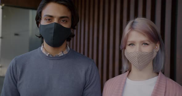 Slow Motion Portrait of Middle Eastern Guy and Caucasian Girl Wearing Face Masks Indoors alt