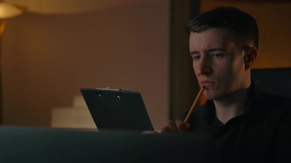 A Man Teaches a Lesson Thinks and Makes a Note in a Text Tablet alt