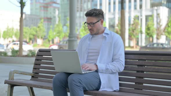 Man Leaving Bench After Closing Laptop alt