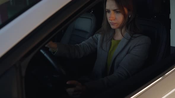 Woman is Angry and Beating Her Head on the Steering Wheel Because Her Car Broke Down alt