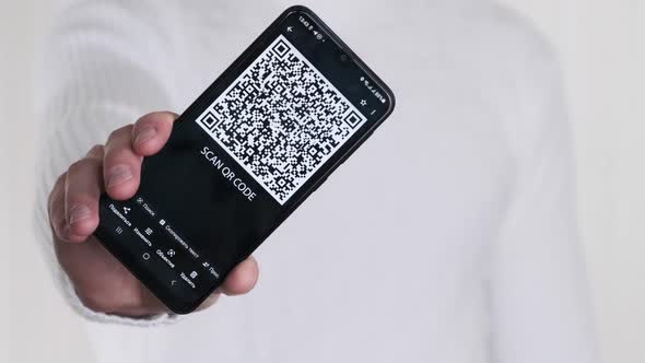 Male Hand Shows QR Code on Smartphone on White Background alt