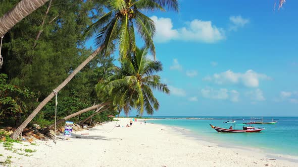 Boats floating near the sandy beach with palms. bright blue sky on a sunny day on tropical island. alt