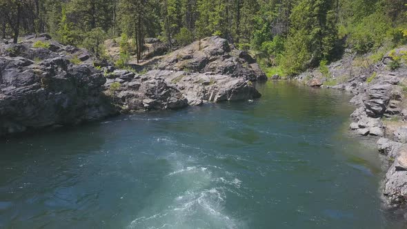 Aerial Drone Traveling Above Flowing Water With Small Rocky Island Below 3