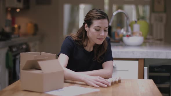 Young adult woman packing cupcakes at home in kitchen