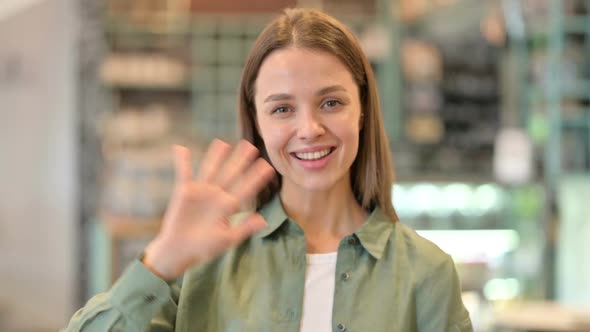 Portrait of Cheerful Woman Waving at the Camera alt