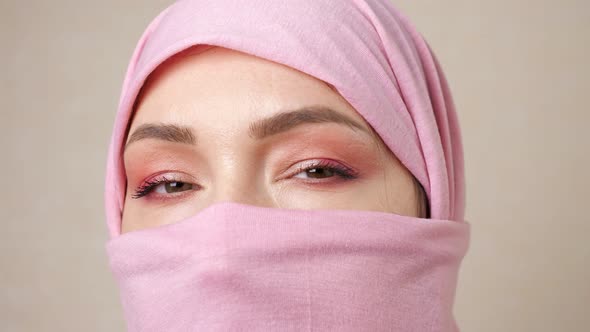 Muslim Woman in a Pink Scarf That Only Opens Eyes alt