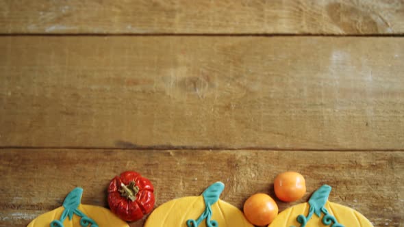 Small pumpkins, tomatoes and sweet food on a wooden table 4k alt