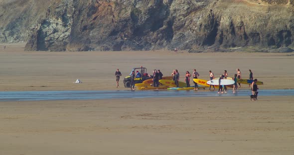 Group Of Rescue Surfers With Surfboard And Quad Bike Gather At The Perranporth Beach. - wide alt